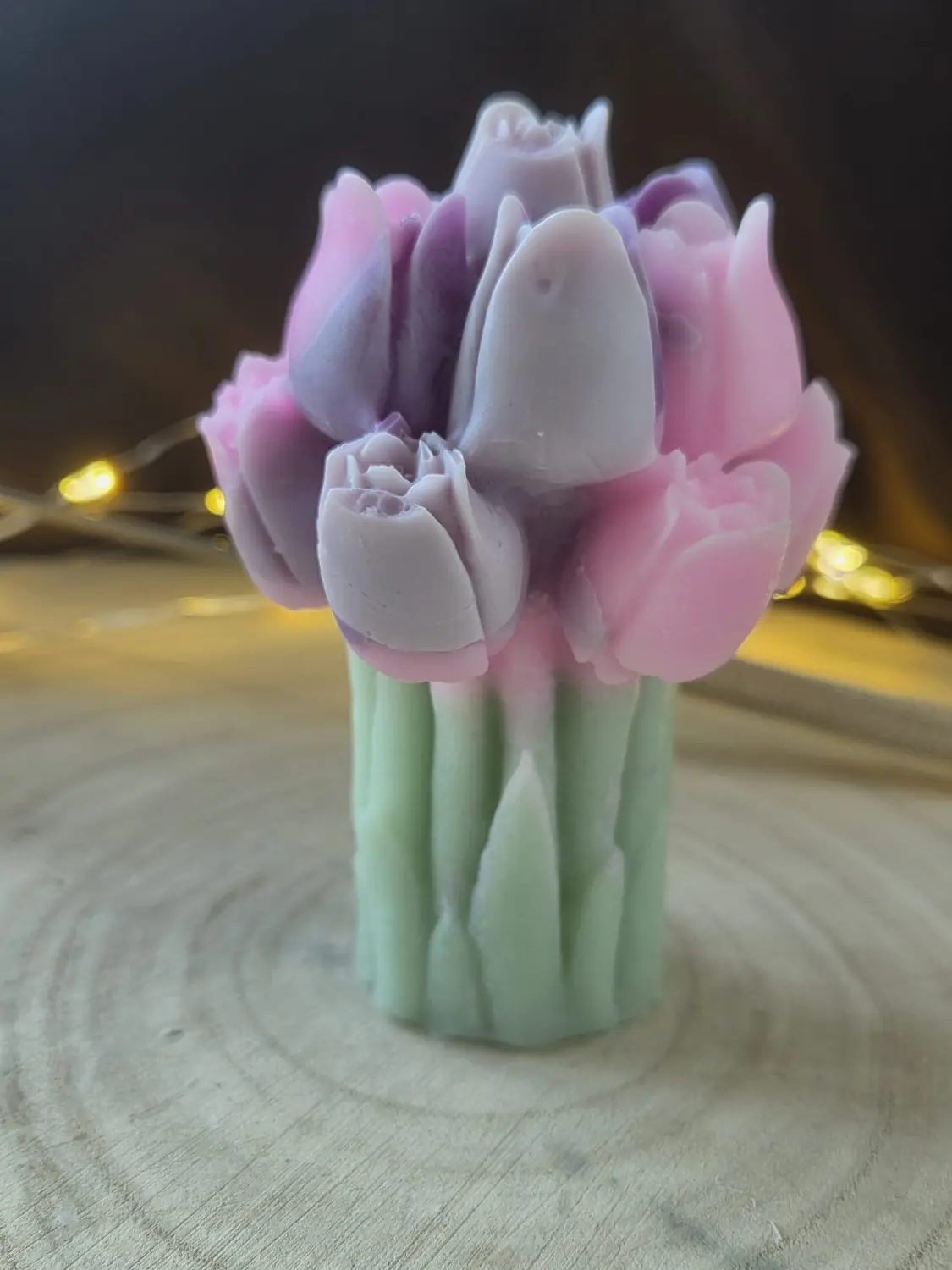 Candle shaped like a bunch of pink and lilac tulips with green stems