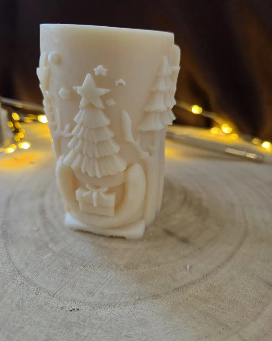 Pale green pillar candle carved with a reindeer and snowflakes
