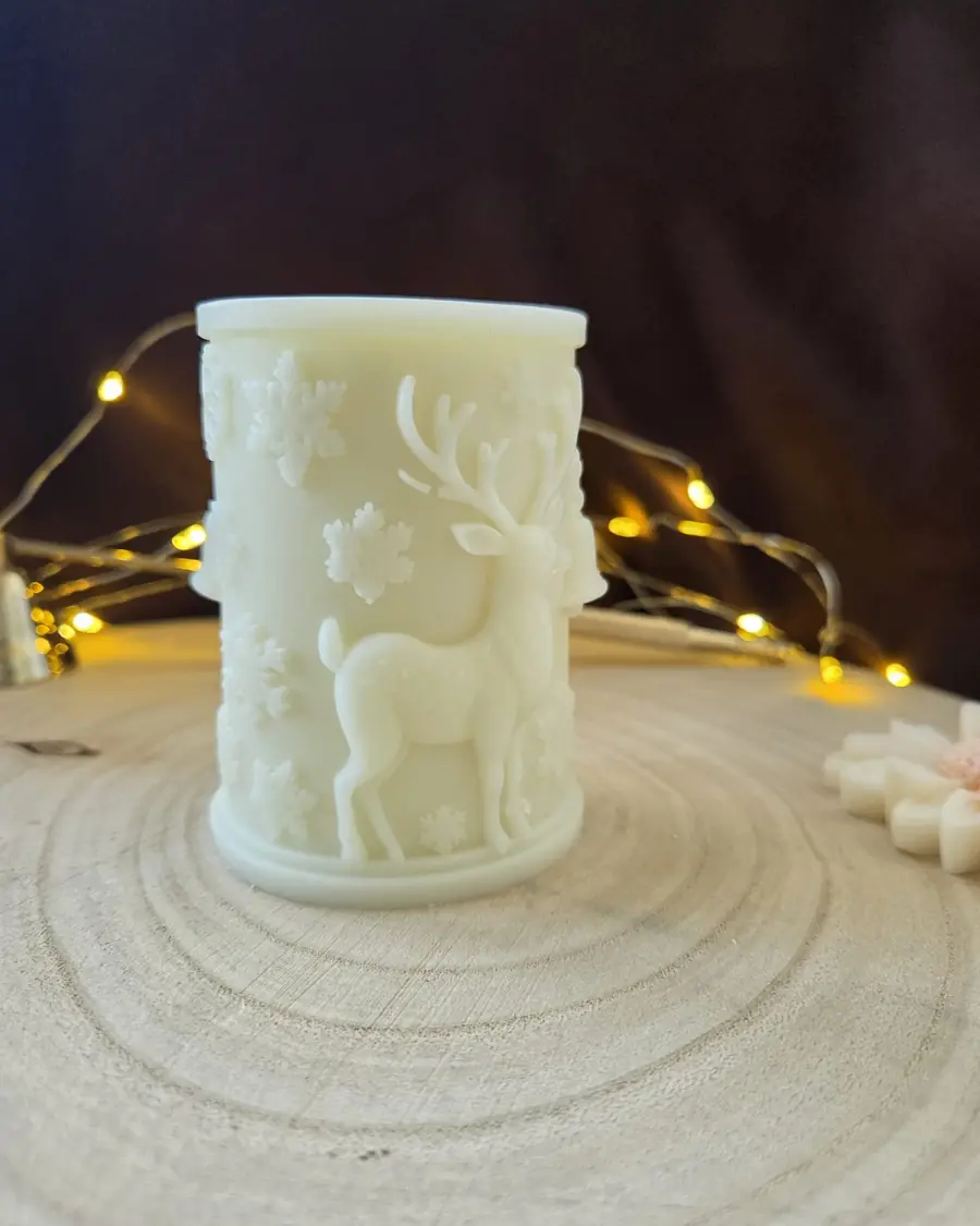 Ivory pillar candle carved with a reindeer head and bare branches