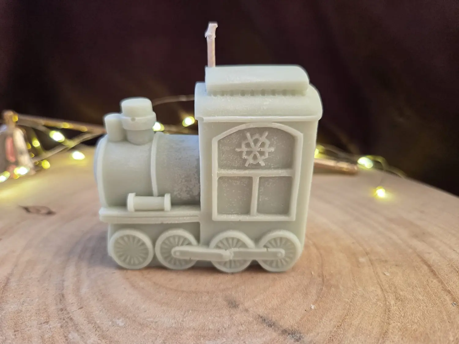 Sage grey train engine candle on a wood slice