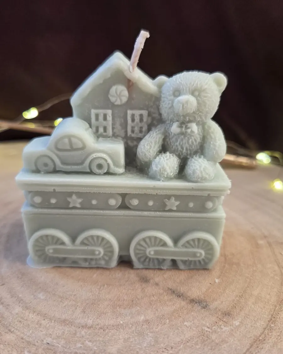 Train carriage candle carrying a house, a car and a teddy