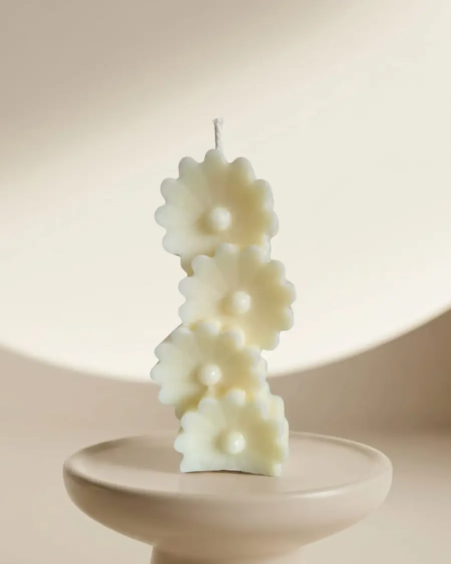 Ivory stacked candle of daisies on a pale stand