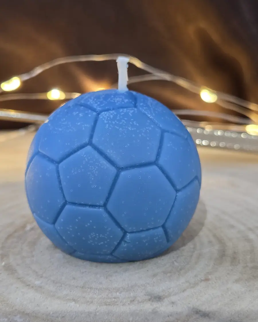 Blue football candle on a wood slice with fairy lights