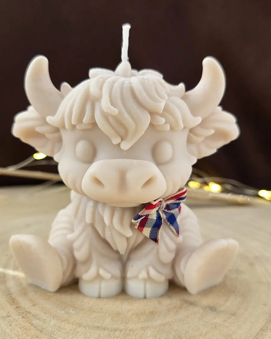 Pale pink Highland cow candle with a checked bow