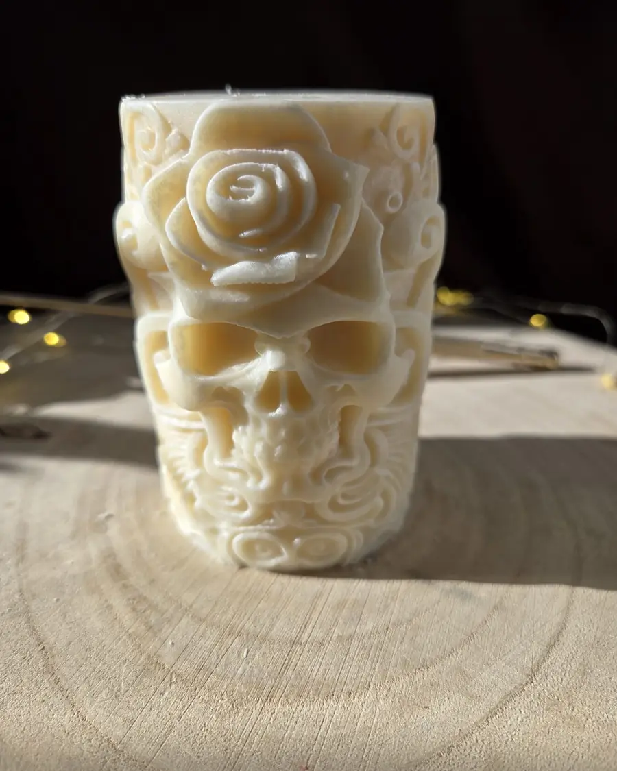 Ivory pillar candle carved with a skull beneath a rose