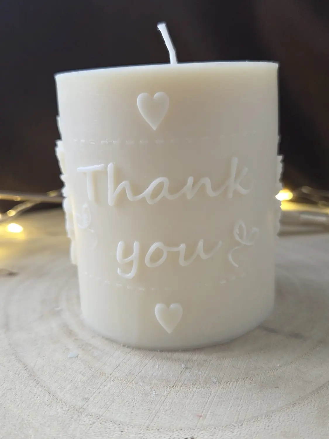 Ivory pillar candle with the words Thank you and two hearts