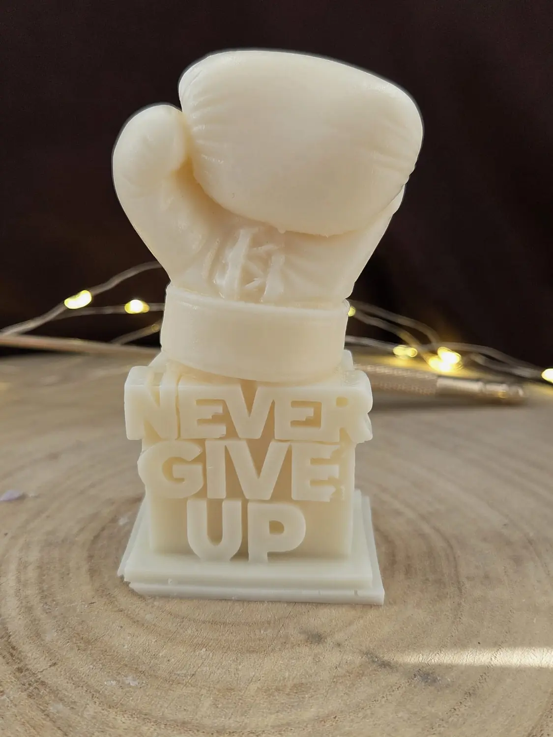 Ivory boxing glove candle on a block with the words Never give up
